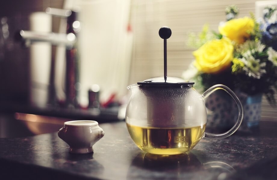 Green tea in a  cup with flowers in the background