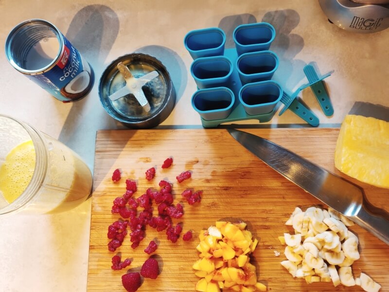 Ingredients on chopping board for coconut & pineapple ice blocks